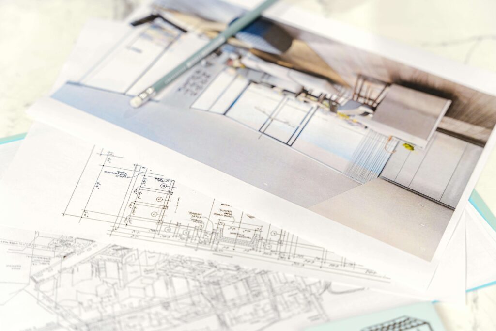 Close-up of architectural blueprints and design plans with a pencil resting on top, illustrating the blueprint basics for detailed project planning and execution.