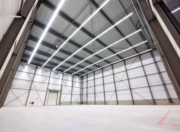 "Interior view of a clear span warehouse building with high ceilings and ample lighting for efficient storage and operations.