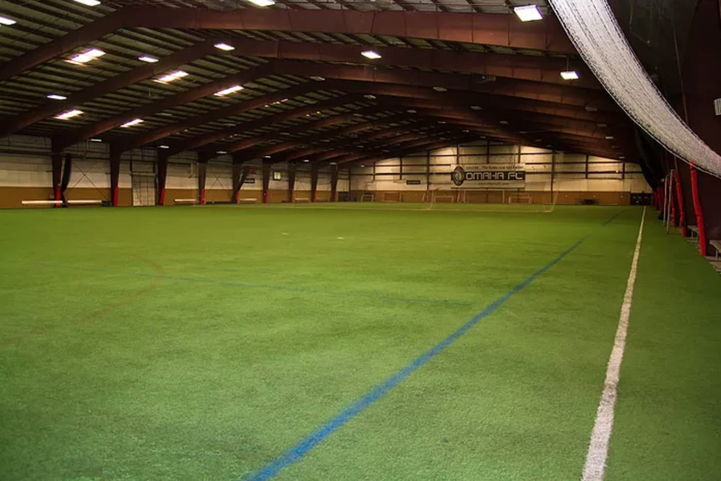 Indoor soccer facility with artificial turf and large open space