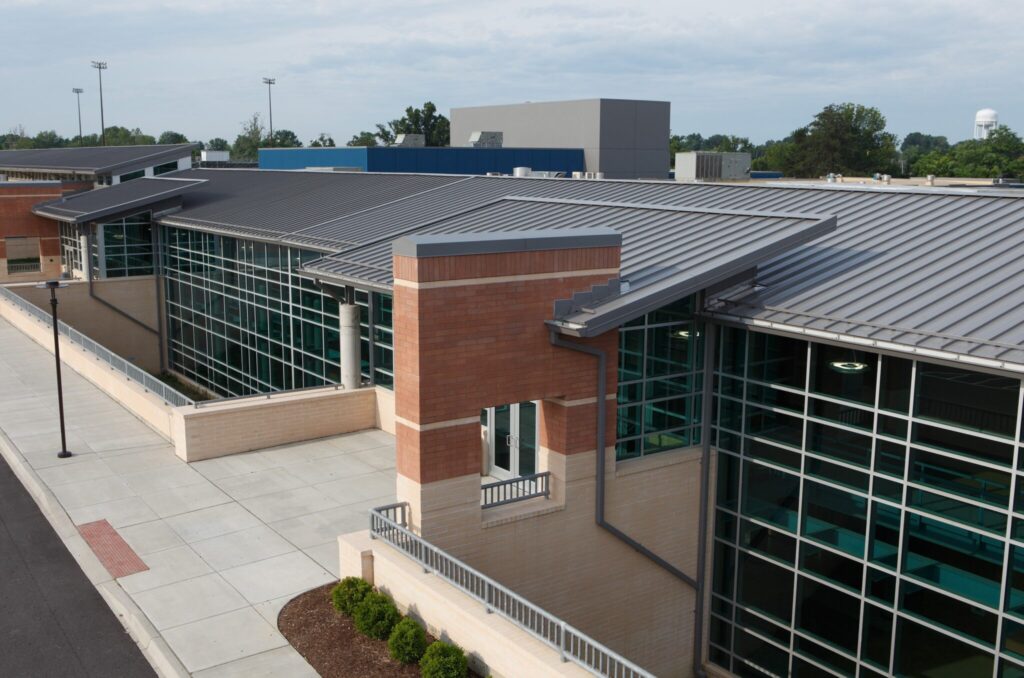 Charlestown High School building featuring large glass windows, brick accents, and metal roofing.