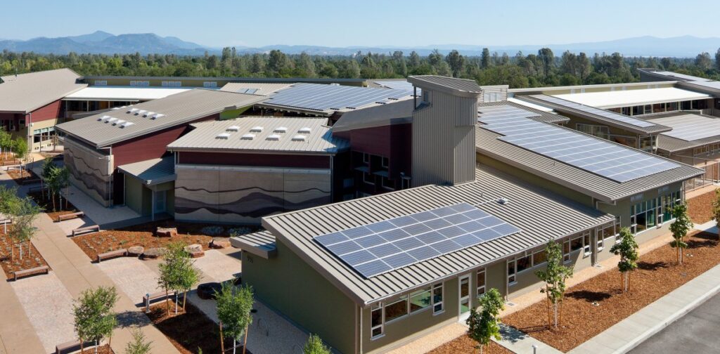 Redding School of the Arts featuring solar panels on the roof and a scenic mountain backdrop.