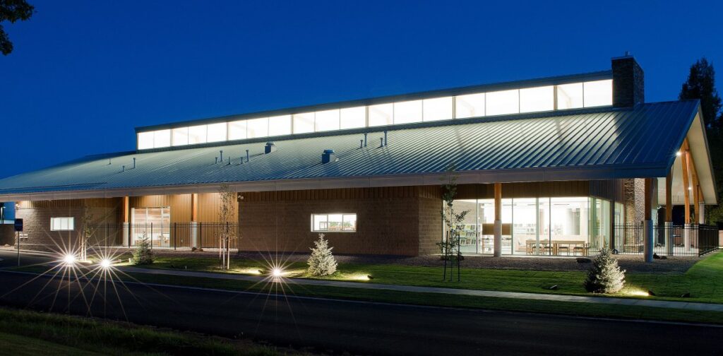 Show Low Public Library with a modern, well-lit exterior and a metal roof, set against a twilight sky.